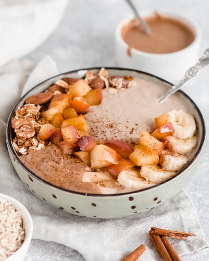apple pie smoothie bowl topped with fruit, nuts and almond butter.