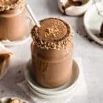chocolate peanut butter protein shake without banana in a glass jar topped with crushed peanuts.