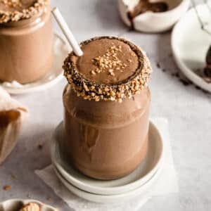 chocolate peanut butter protein shake without banana in a glass jar topped with crushed peanuts.