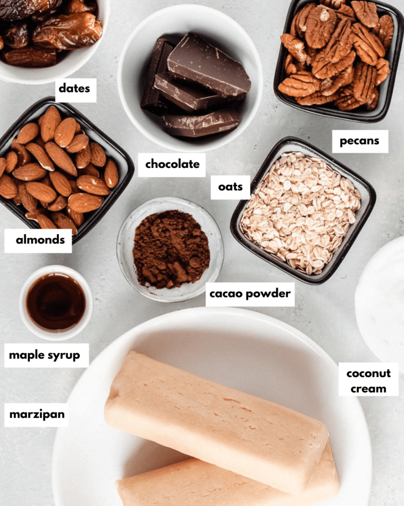 All ingredients needed for marzipan chocolate cake: dates, chocolate, oats, pecans, almonds, cacao powder, maple syrup, marzipan, coconut cream