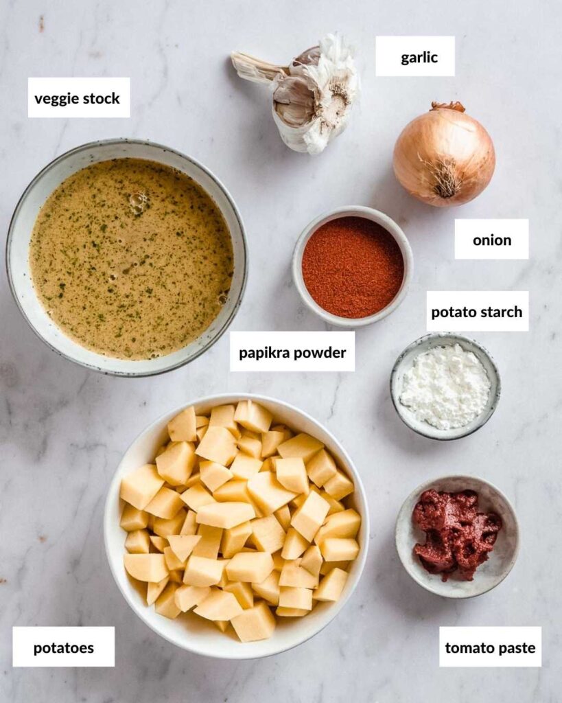 all ingredients needed to make this potato goulash: veggie stock, glaric, onion, potato starch, paprika powder, potatoes, tomato paste