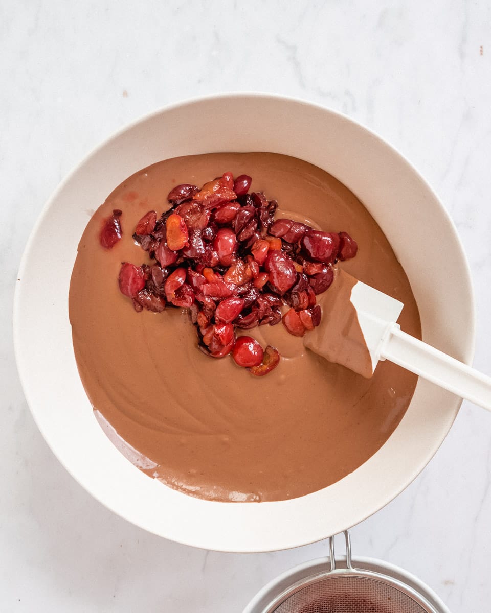 vegan chocolate mousse in a big bowl with some added cooked cherries
