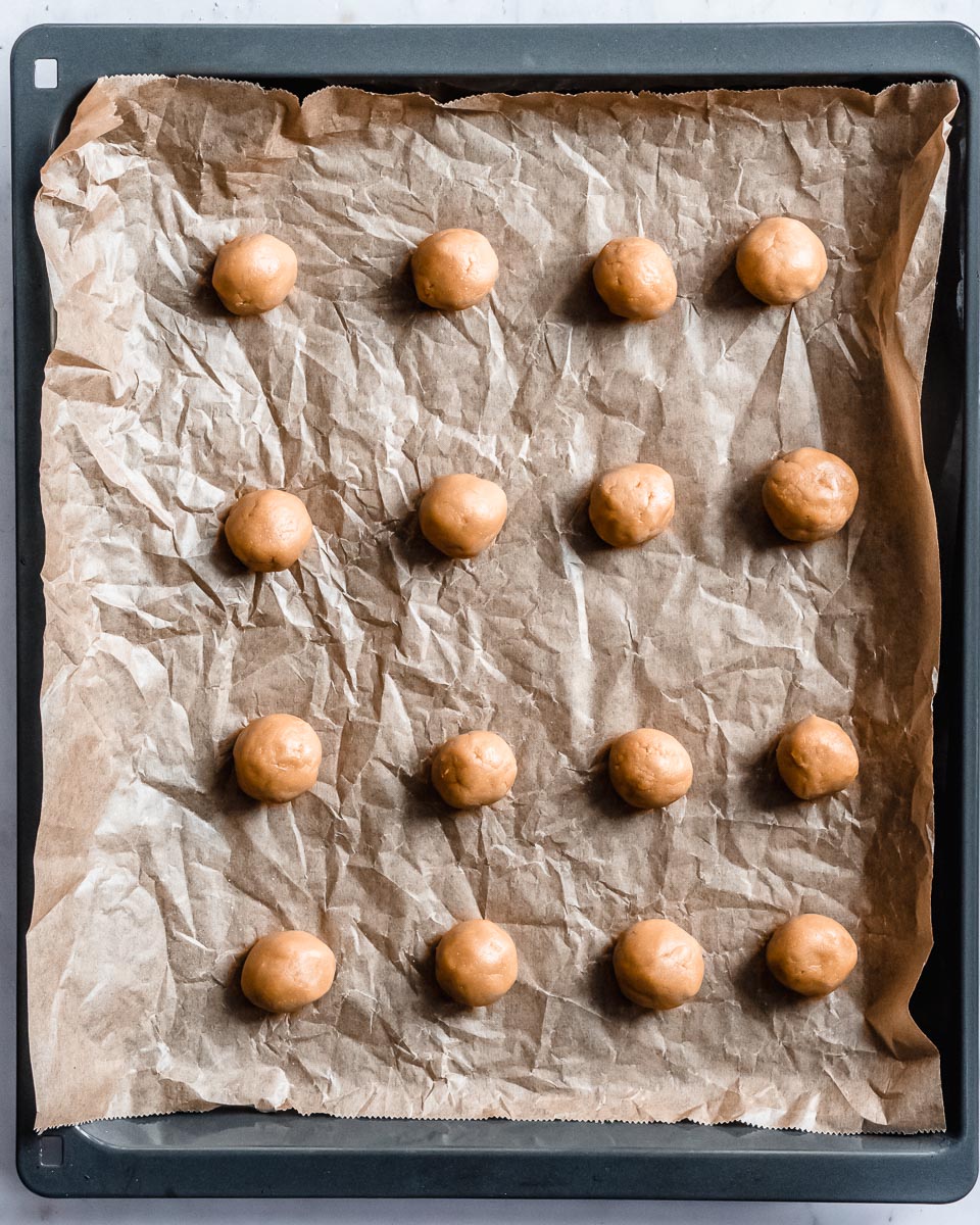 little balls of peanubutter cookie dough on a baking tray