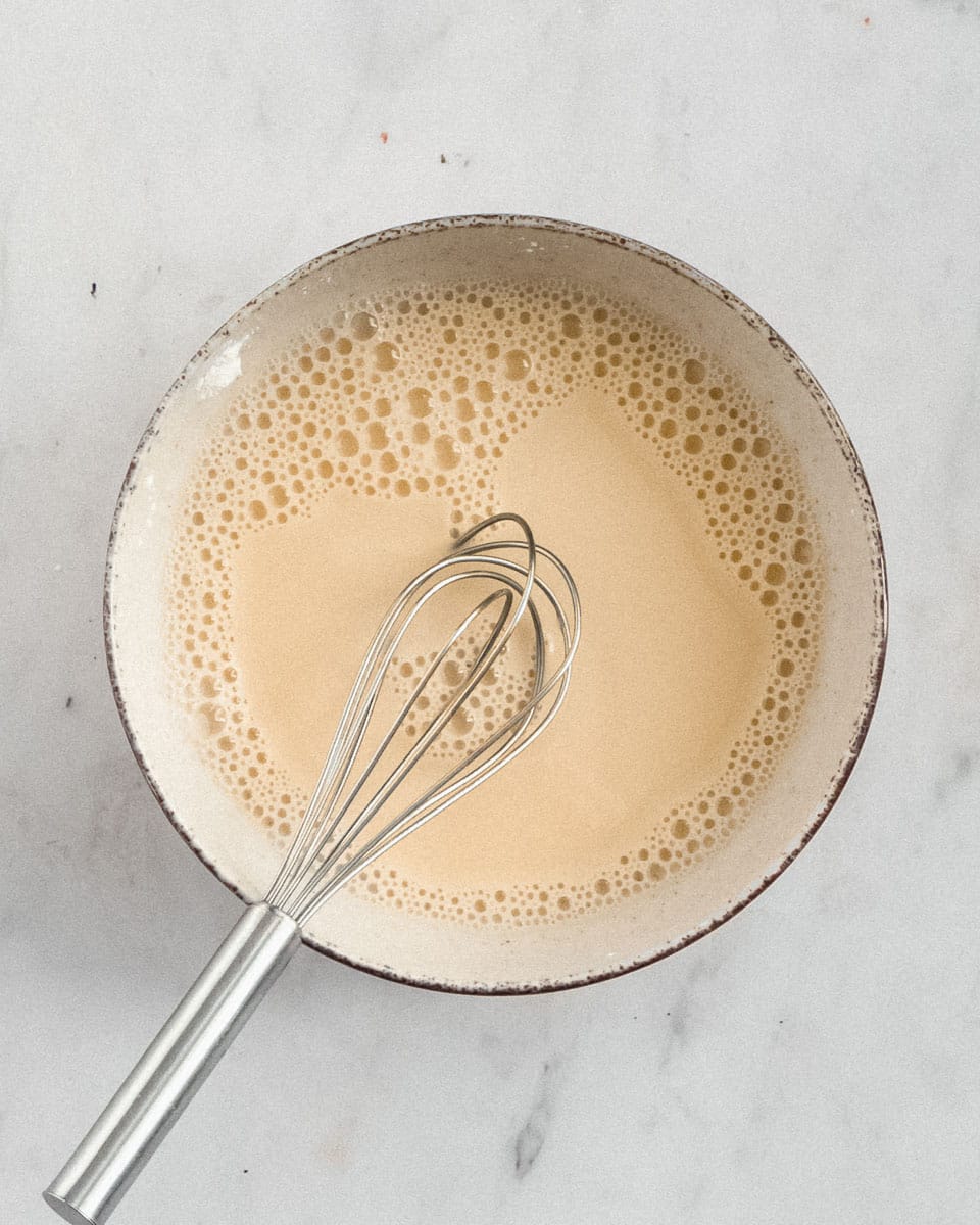 almond milk and pudding powder mixed togeher with a whisk in a small bowl
