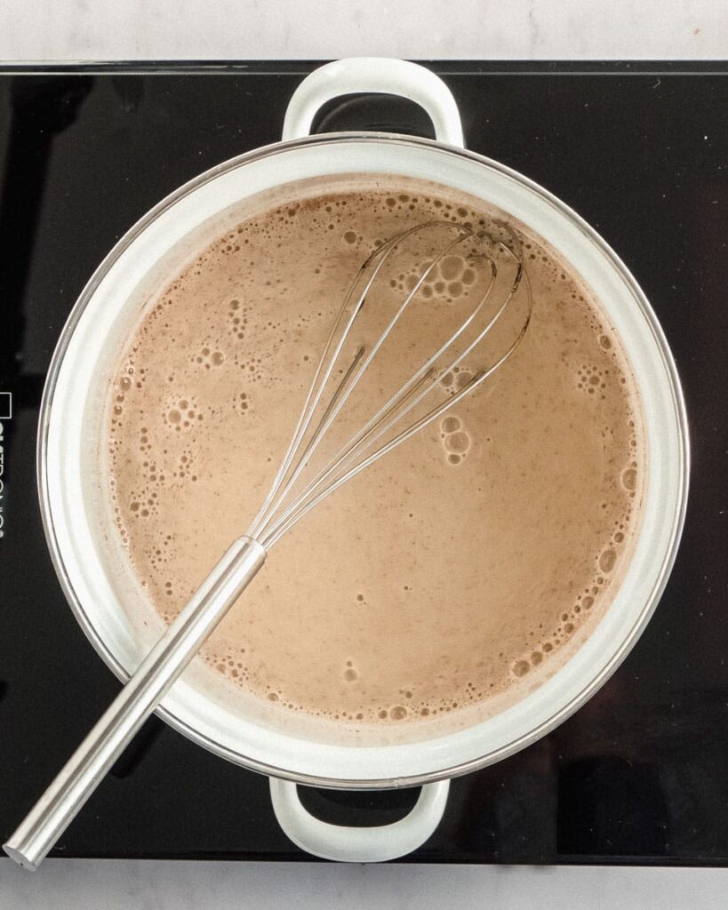 almond milk eggnog with eggs in a saucepan.