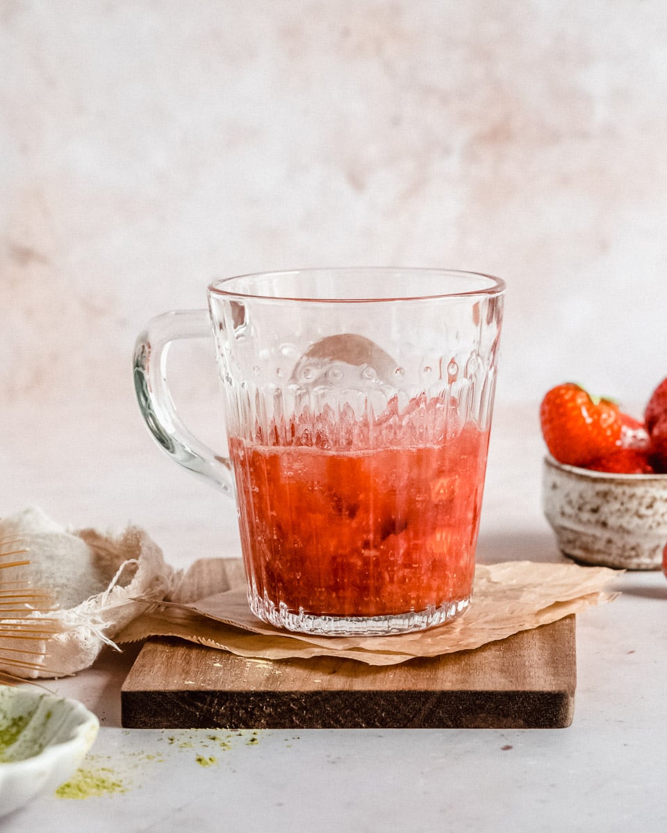 cup filled with blended strawberry puree and ice cubes on top