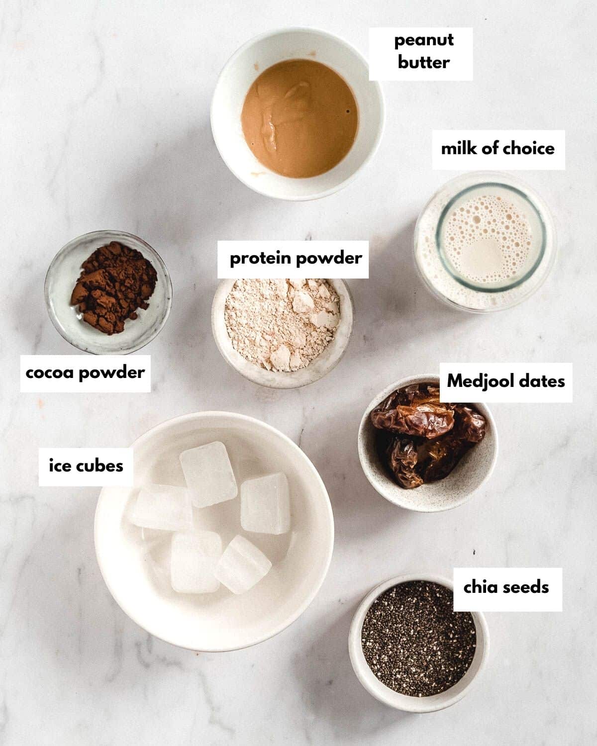 ingredients needed to make chocolate peanut butter protein shake without banana. Peanut butter, milk of choice, protein powder, cocoa powder, Medjool dates, ice cubes, chia seeds.