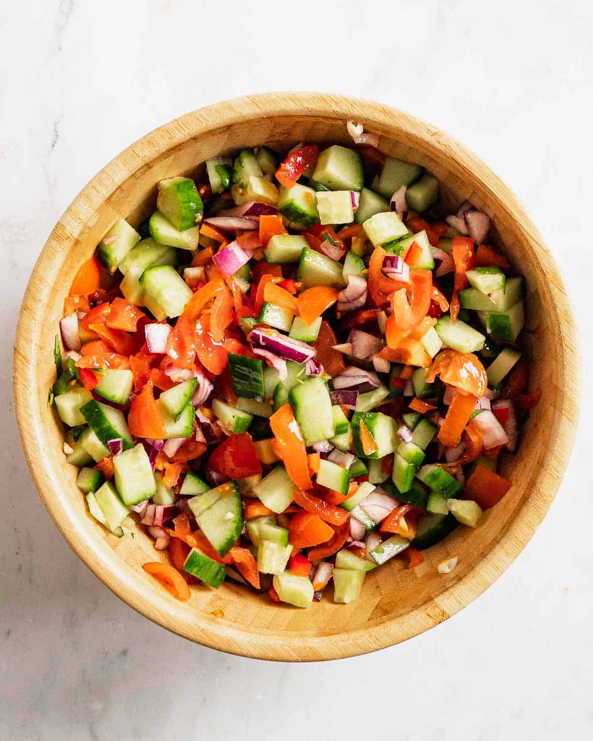 chopped tomatoes, jalapeno, cucumber, cilantro, onion, lime juice and salt tossed together in a bowl.