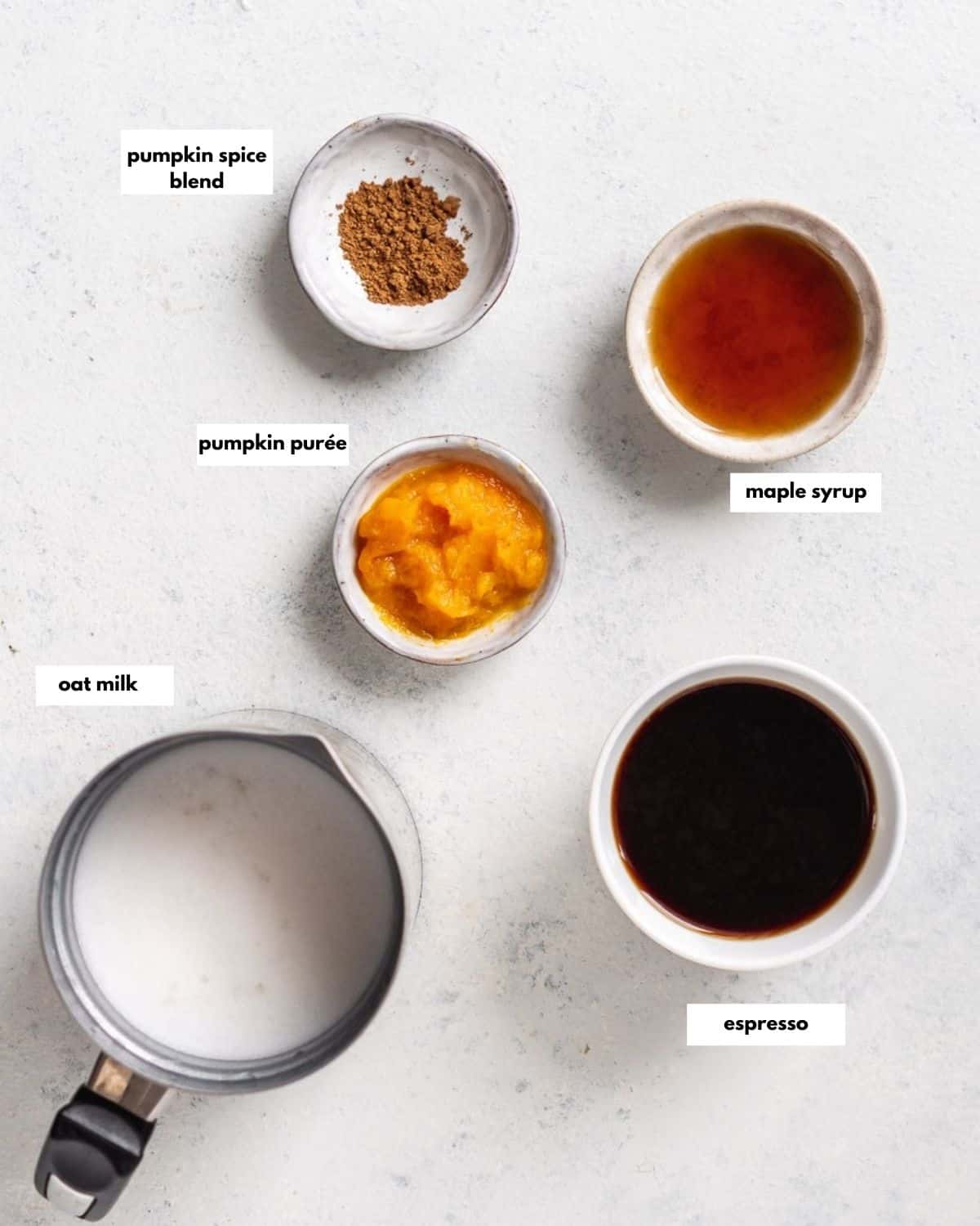 all ingredients needed to make pumpkin spice latte with oat milk: espresso, oat milk, pumpin puree, maple syrup, pumpkin spice blend