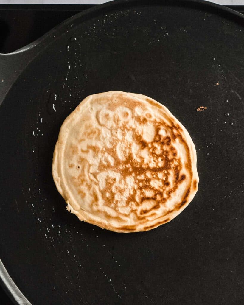 cooked pancake in a pan, flipped.