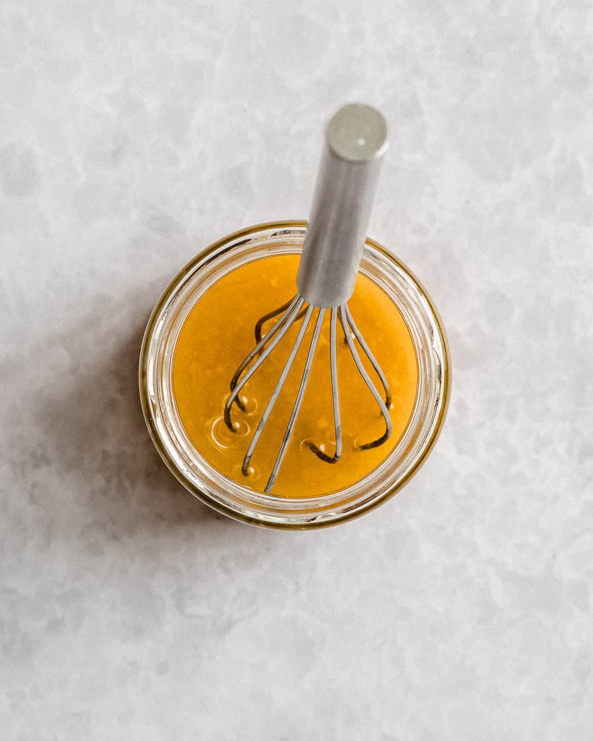 all of the dressing ingredients whisked together with a whisk in a small jar.