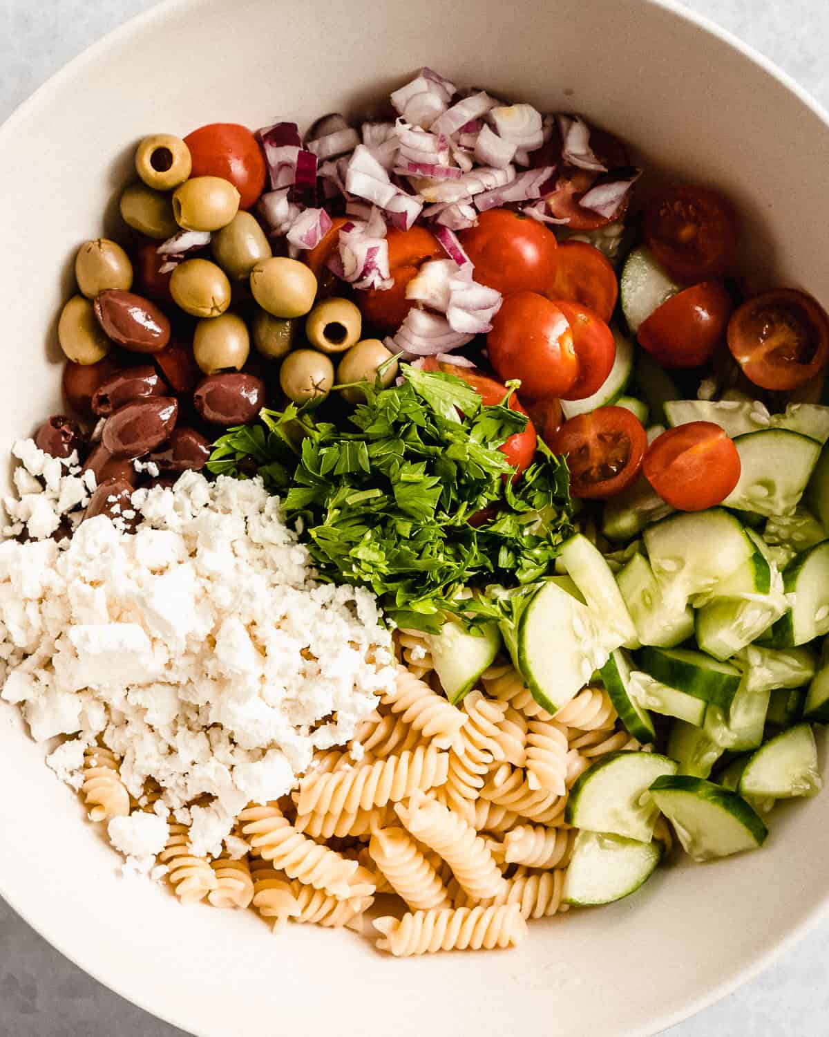 all of the ingredients for the pasta salad in a bowl.
