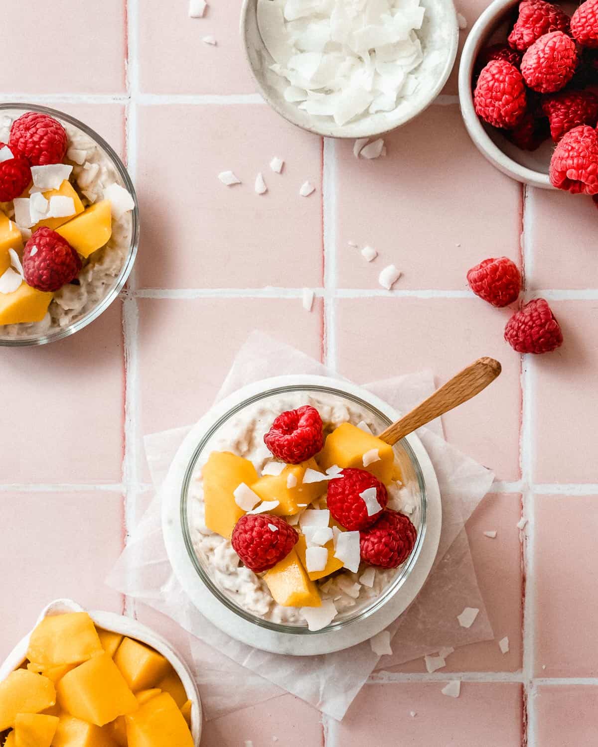 2 jars of coconut milk overnight oats topped with raspberries and mango pieces.