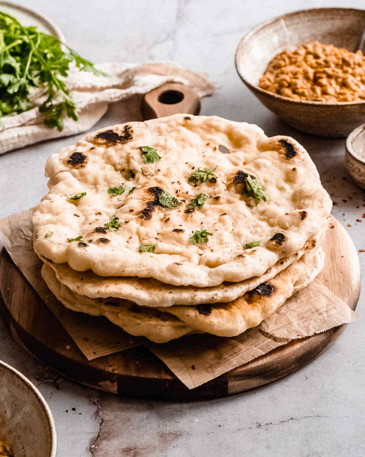 stack of naan bread on a wooden board.