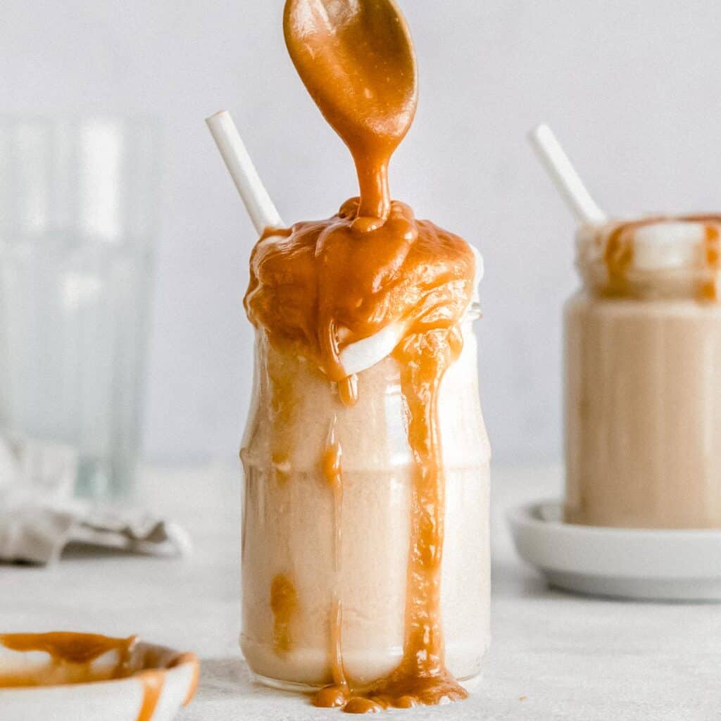 caramel smoothie topped with vegan whipped cream and vegan caramel sauce.