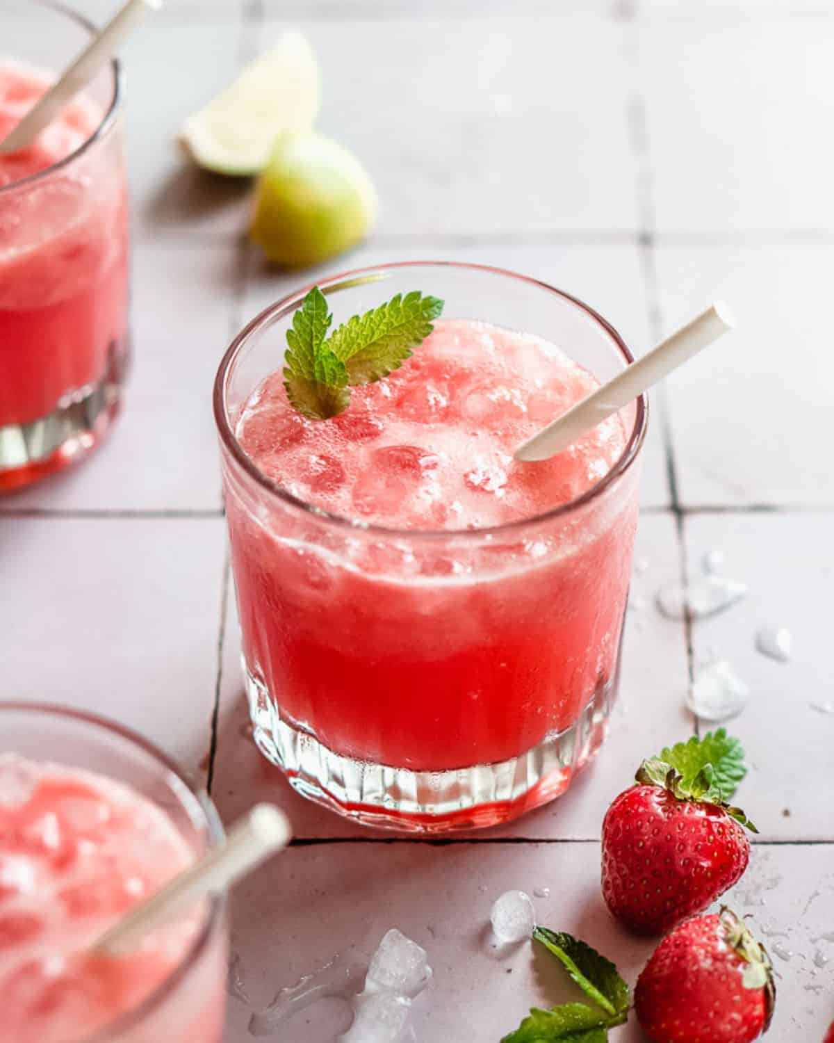 watermelon mojito mocktail in a serving glass with fresh mint leaves on top.