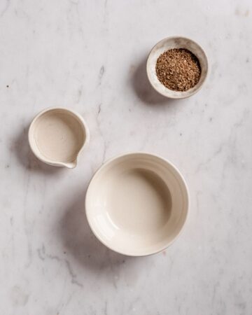 1 bowl, some water and ground flaxseed on a table.