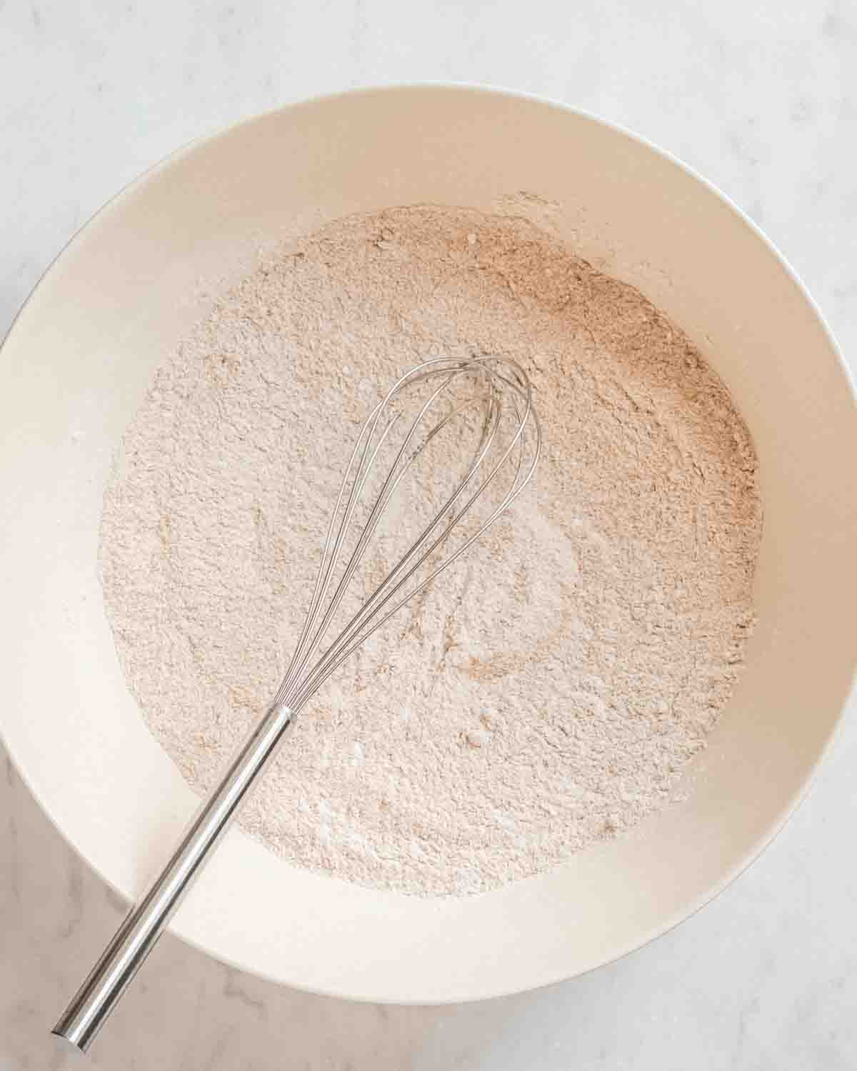 dry ingredients for banana applesauce muffins whisked together in a bowl.