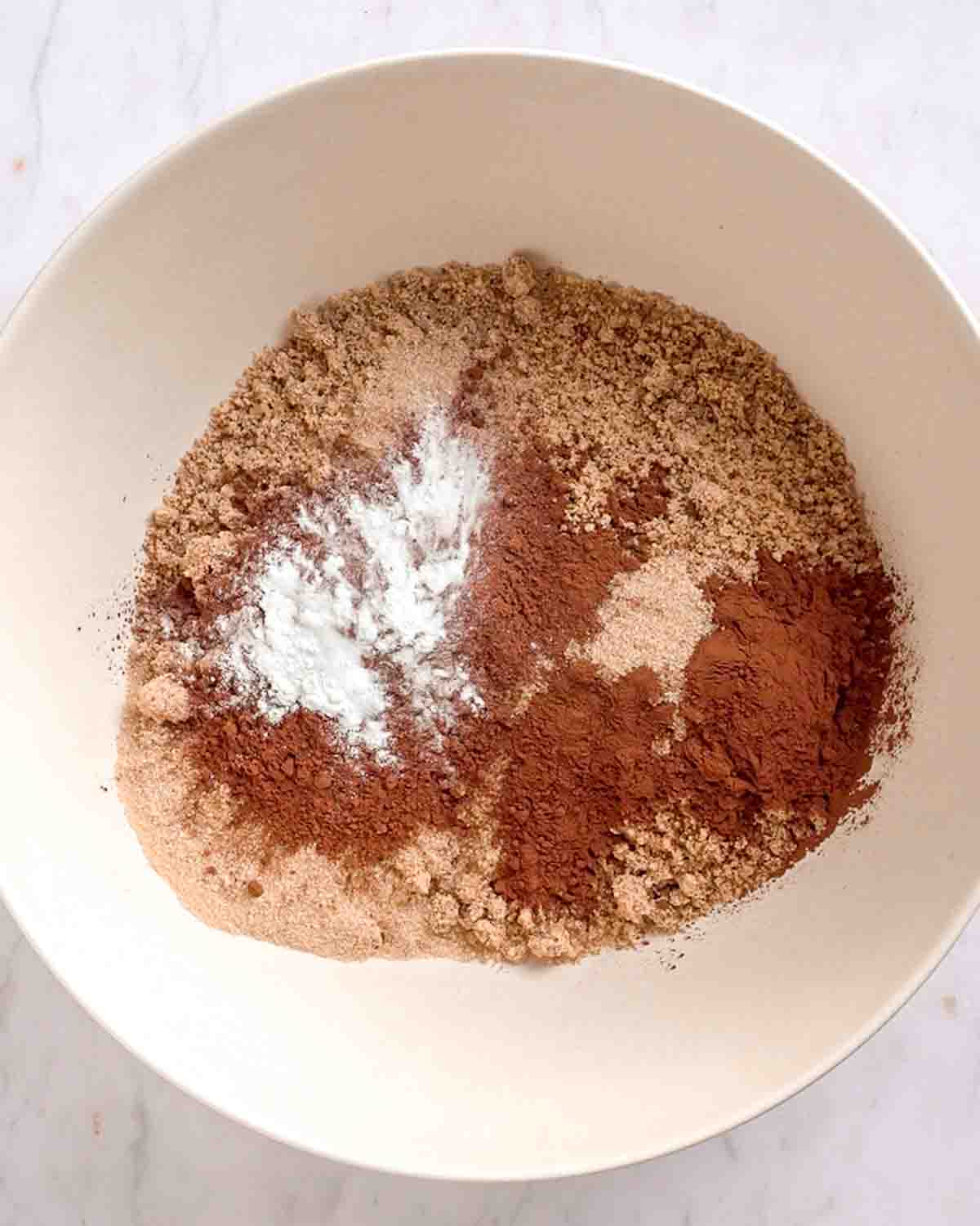 ground roasted hazelnuts, cocoa powder, baking powder and brown sugar added to a large mixing bowl.