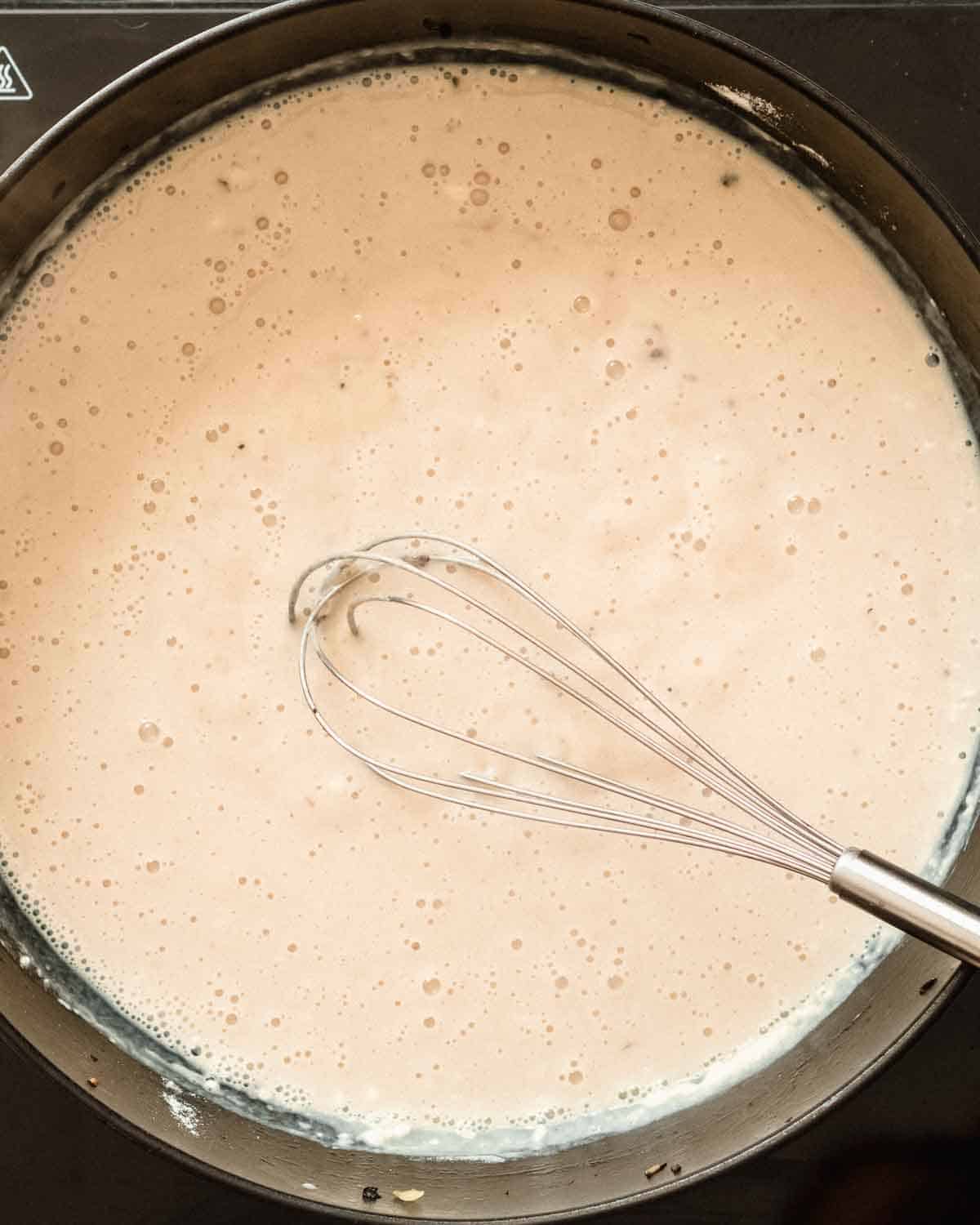 milk added to the toasted flour while whisking.