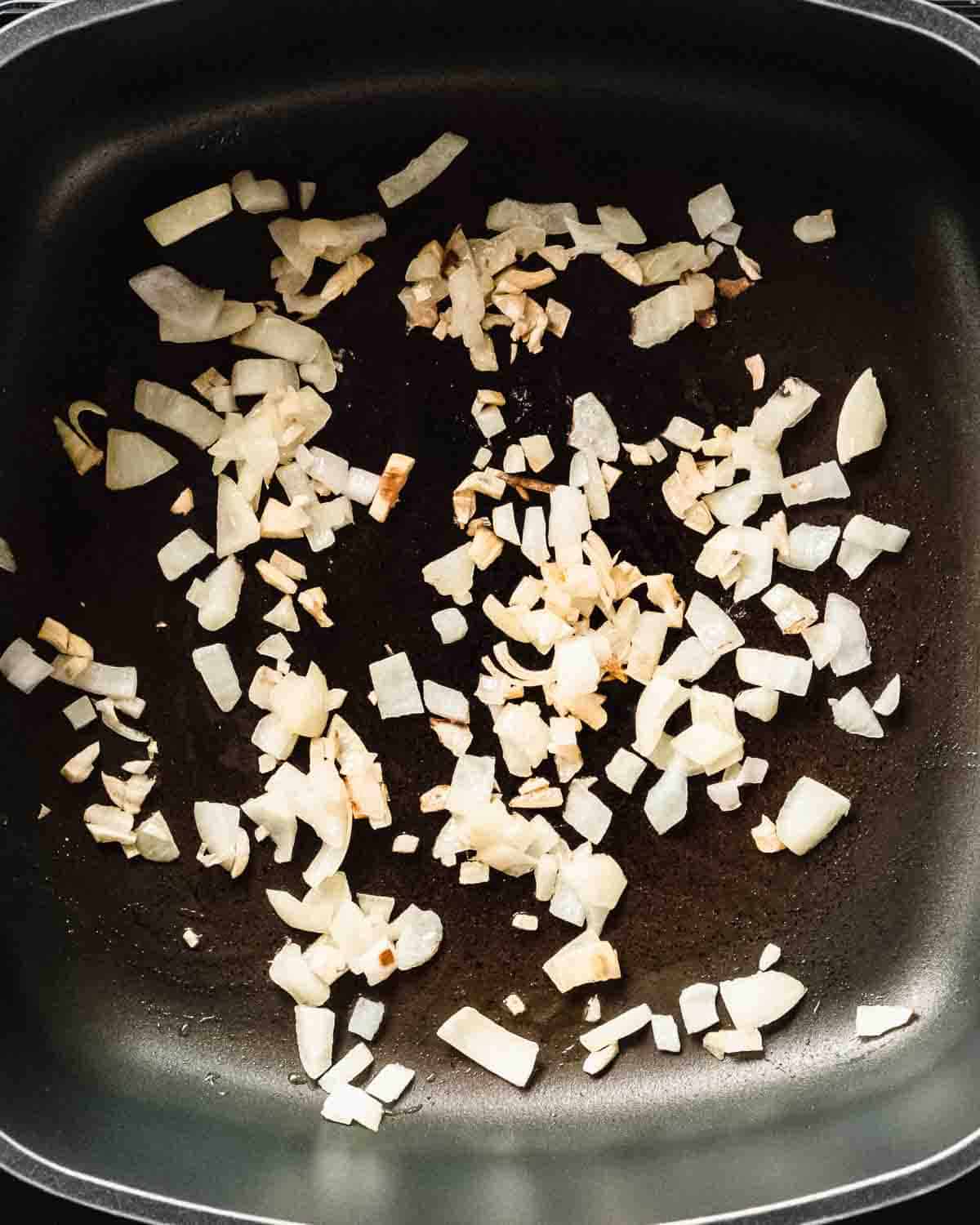 onion and garlic sauteed in a pan.