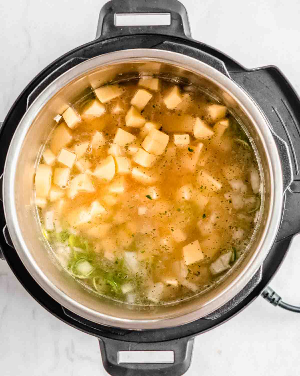 sauteed onion, garlic and leek in a the instant pot, with salt, pepper, potato cubes and veggie broth added