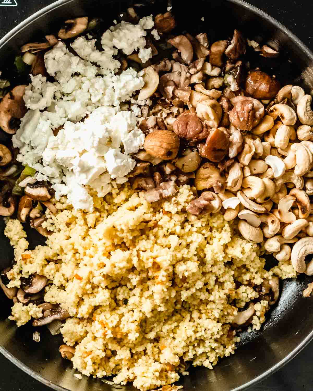 cooked couscous, feta, cooked chestnuts and toasted cashews added to the mushroom mix in the pan.
