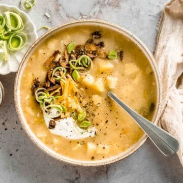 1 big bowl of vegetarian instant pot potato soup topped with greek yogurt, cheddar, leek and cripsy mushroom "bacon"