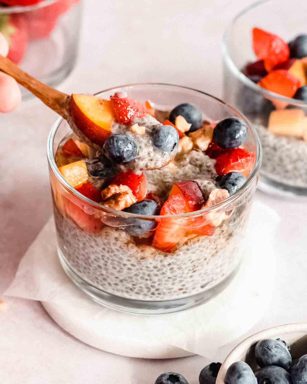 almond milk chia seeds with a wooden spoon and fresh fruits in it.