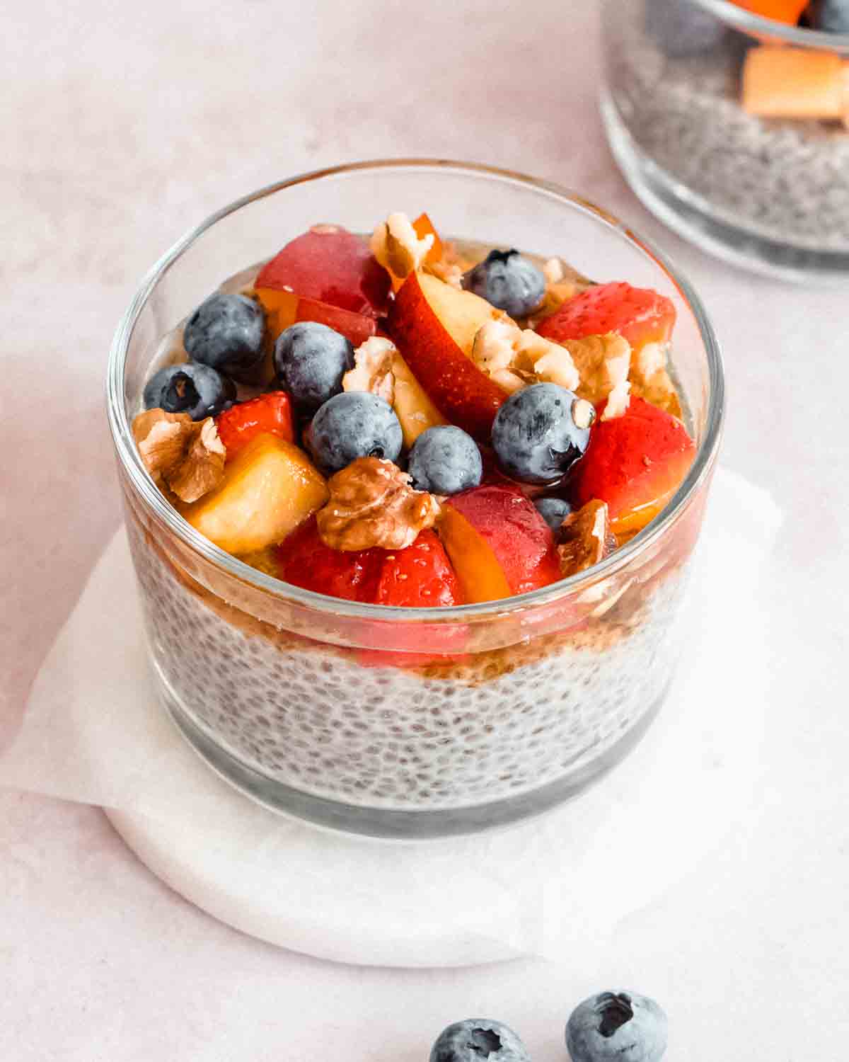 chia seeds in a glass bowl topped with fresh fruits and nuts.
