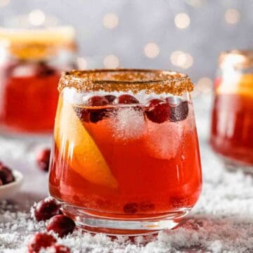 1 glass of non alcoholic holiday punch with sugar-rim, inthe background 2 more glasses of punch