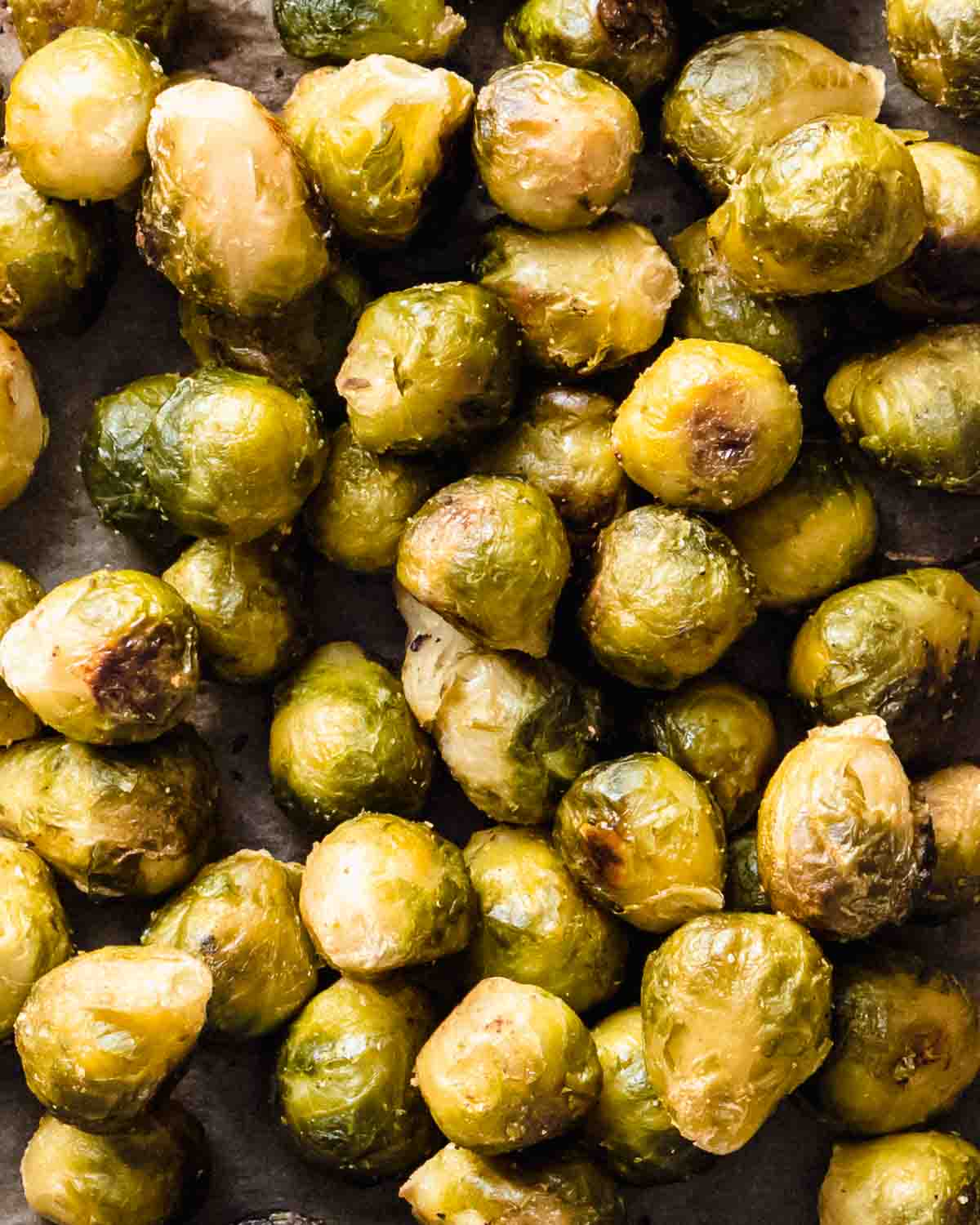 close up of roasted frozen brussel sprouts on a baking tray.