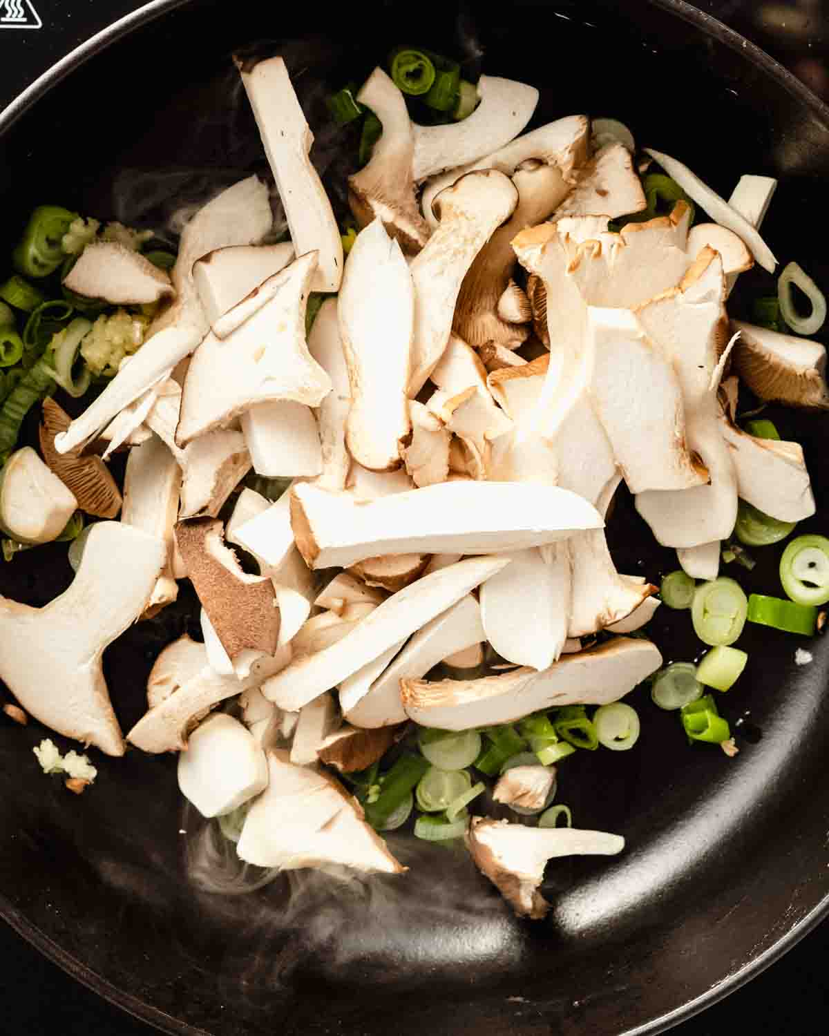 sliced mushrooms added to the pan.