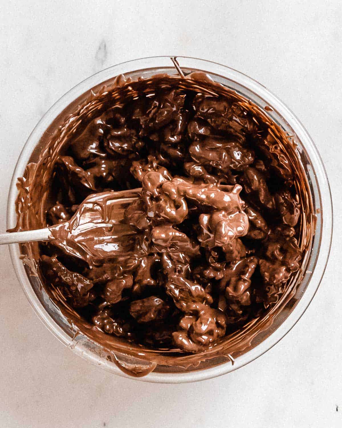 fork removeing one chocolate covered walnut from the bowl.