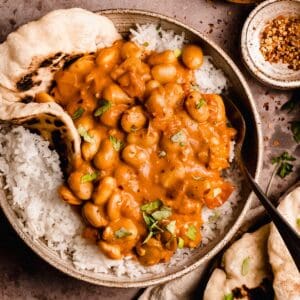butter bean curry in a bowl on basmati rice and naan.