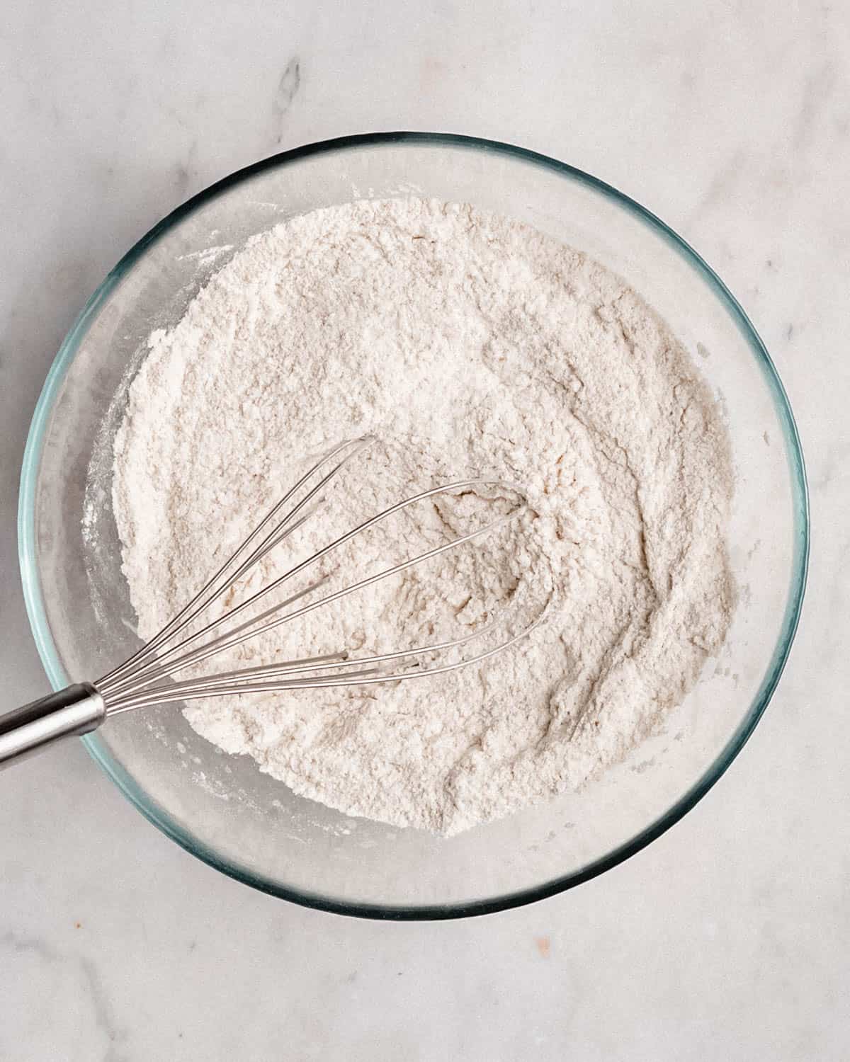 flour in a whisking bowl with a whisk.