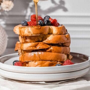 french toast topped with fresh berries and maple syrup.