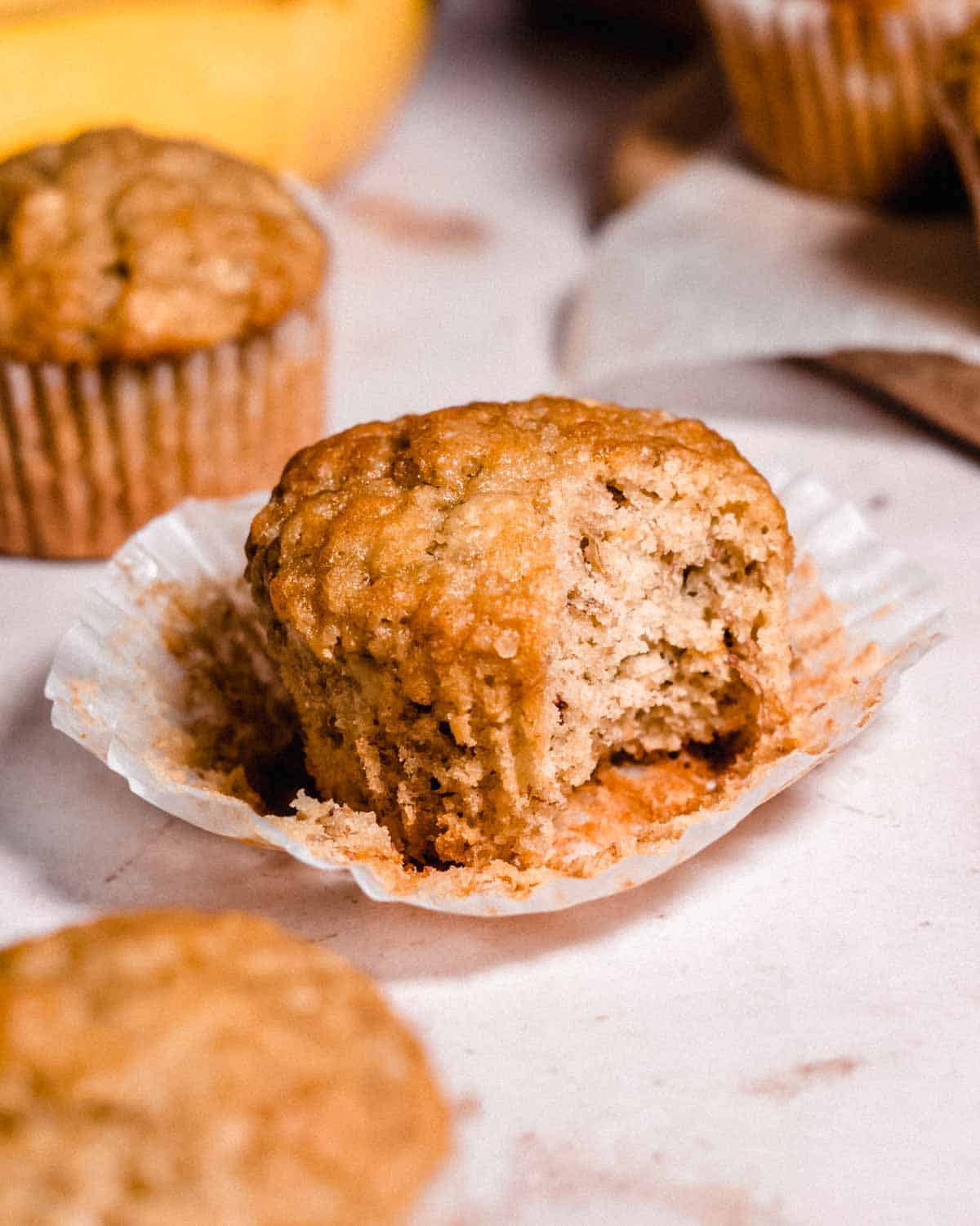 unwrapped banana muffin with one bite bitten off.
