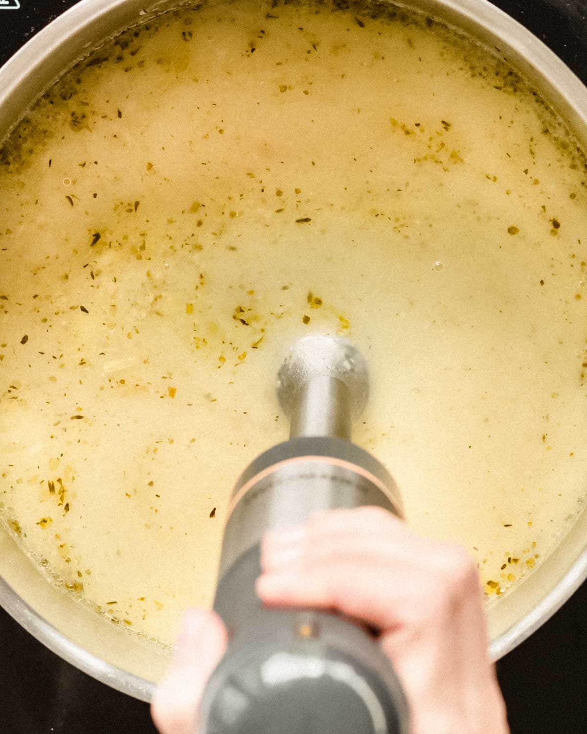 potato soup being pureed in a soup pot.