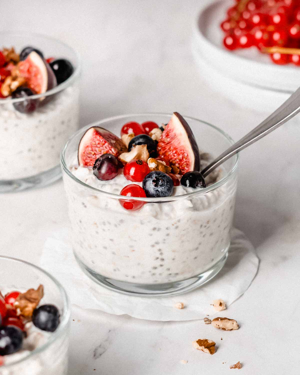 Kefir overnight oats in a jar topped with fresh figs, blueberries and red currant.