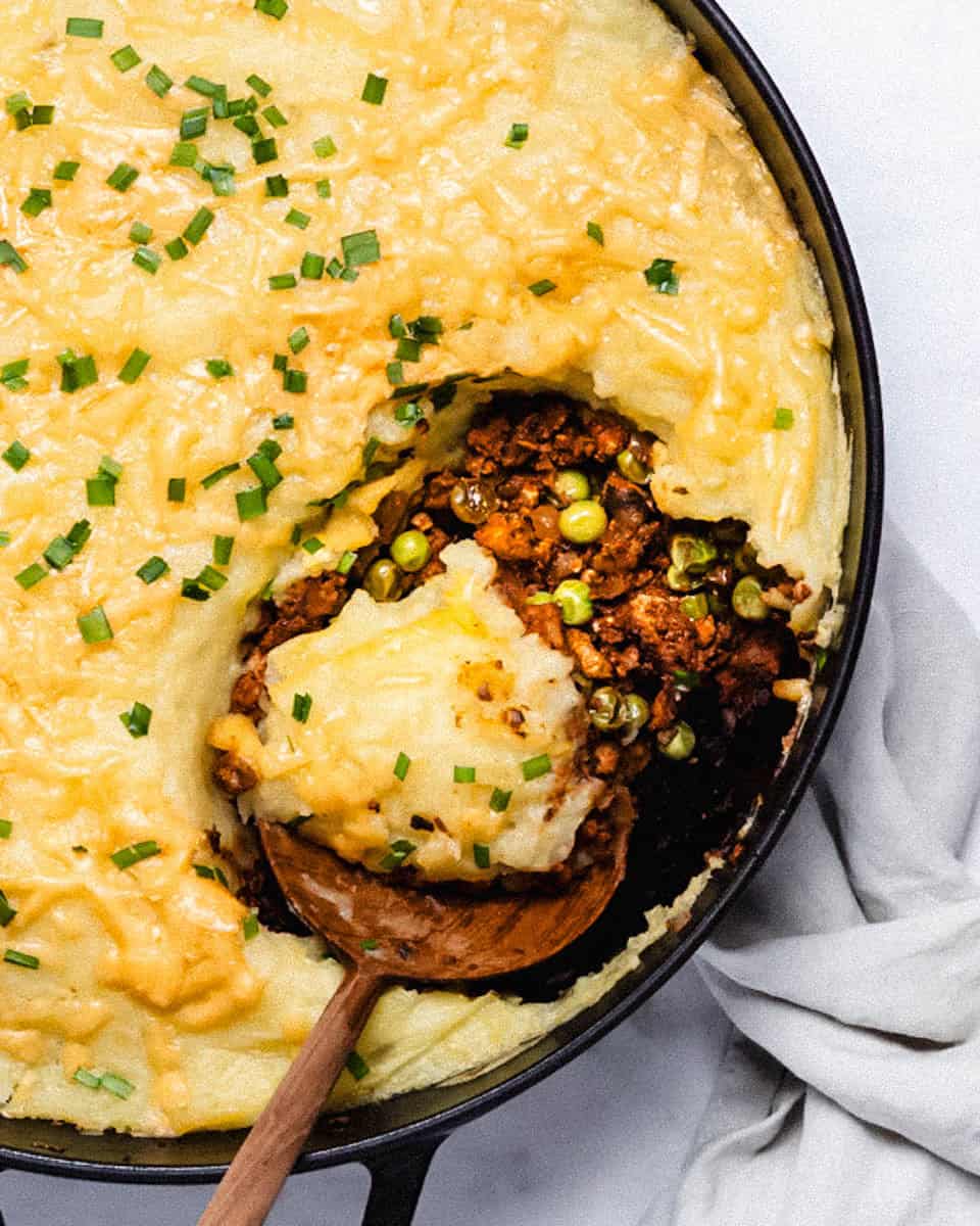 Shepherd's pie seen from above with a big spoon in it.