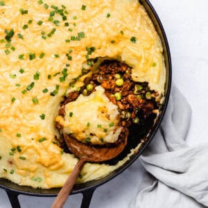 Shepherd's pie seen from above with a big spoon in it.