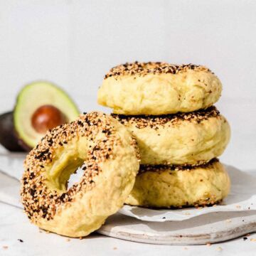 4 Avo bagels on a white marble board.