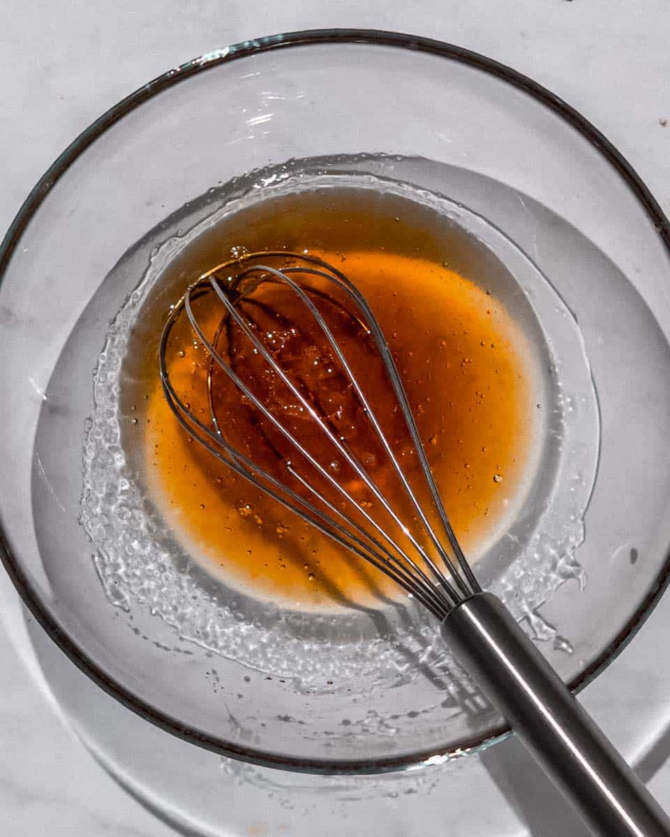 All wet ingredients for this granola whisked together in a bowl.