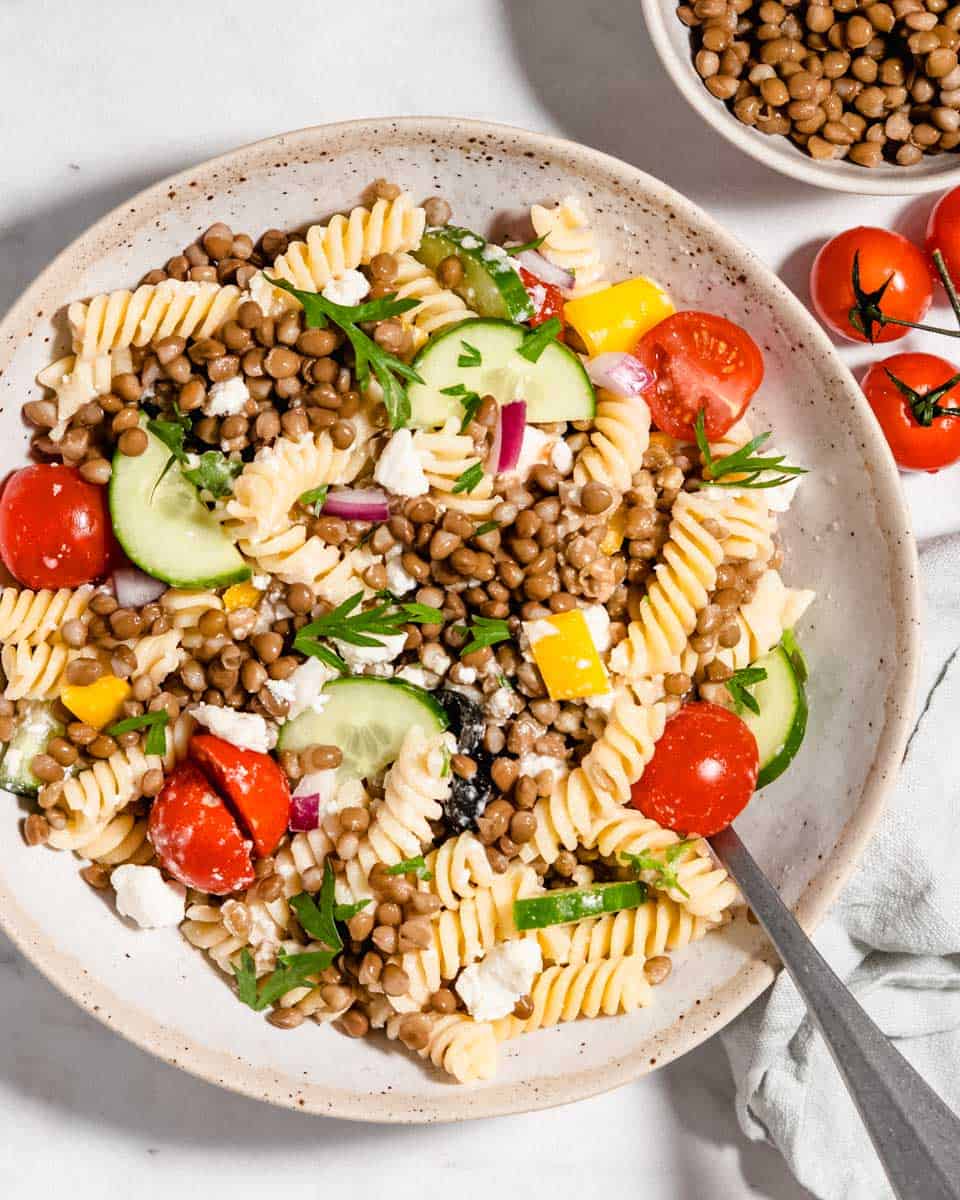 Birds-eye view of a pasta salad in a bowl tossed with dressing.