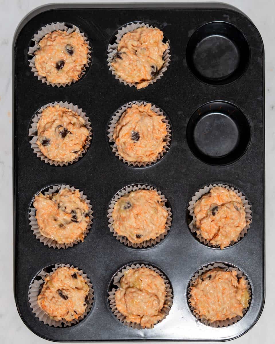 10 muffins in a muffin tin ready to be baked.