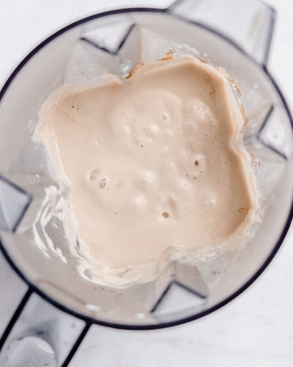 Blended cheesecake filling in a blender jug.