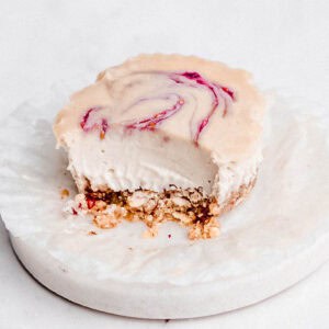 A creamy mini vegan cheesecake with a spoonful taken out, showing its smooth texture