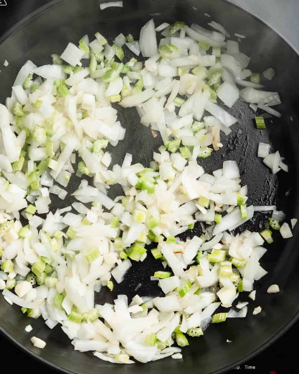 Onion, garlic and celery sauteed in a pan.