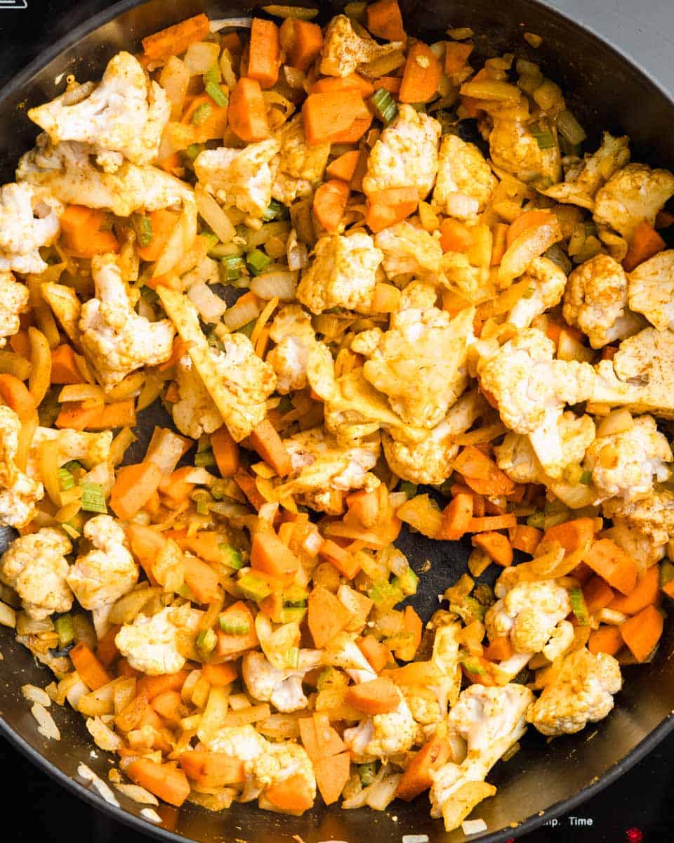 All the veggies and spices in a pan.
